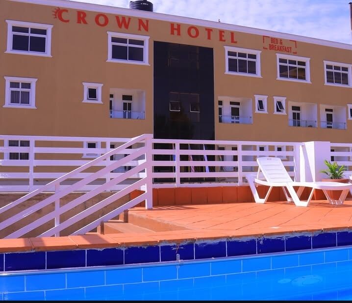 Poolside at Crown Boutique Hotel with sun loungers and the hotel facade